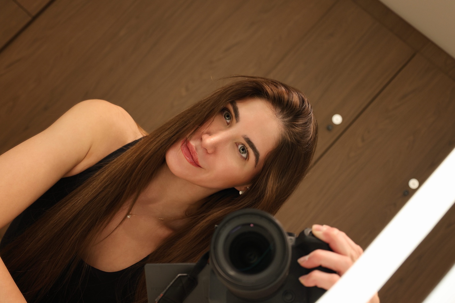 Cristína with a camera reflected in a mirror